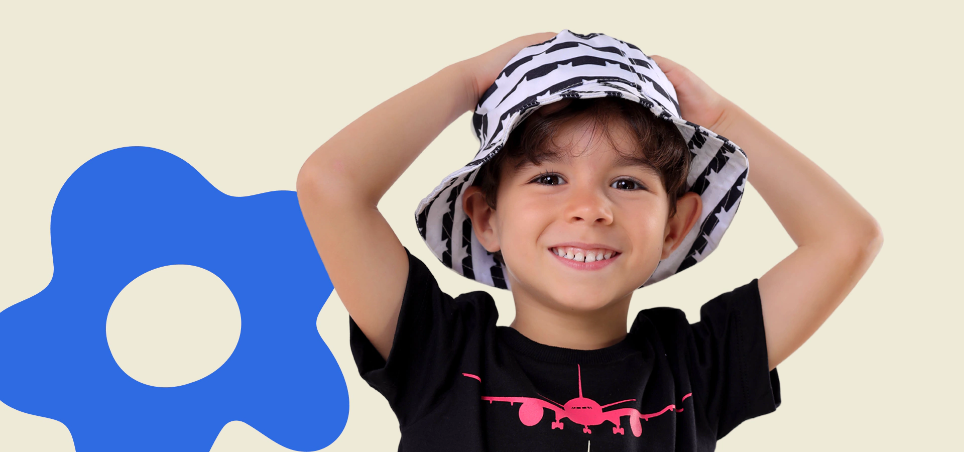 Menino sorrindo com camiseta preta e chapéu da Holila.